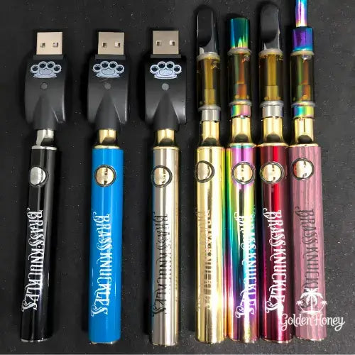 Variety of sleek THC distillation vape pens with USB chargers on a black background.