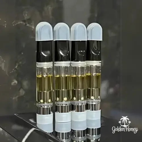 Cuatro cápsulas de destilado THC premium de 1ml, con aceite orgánico concentrado en frascos transparentes.