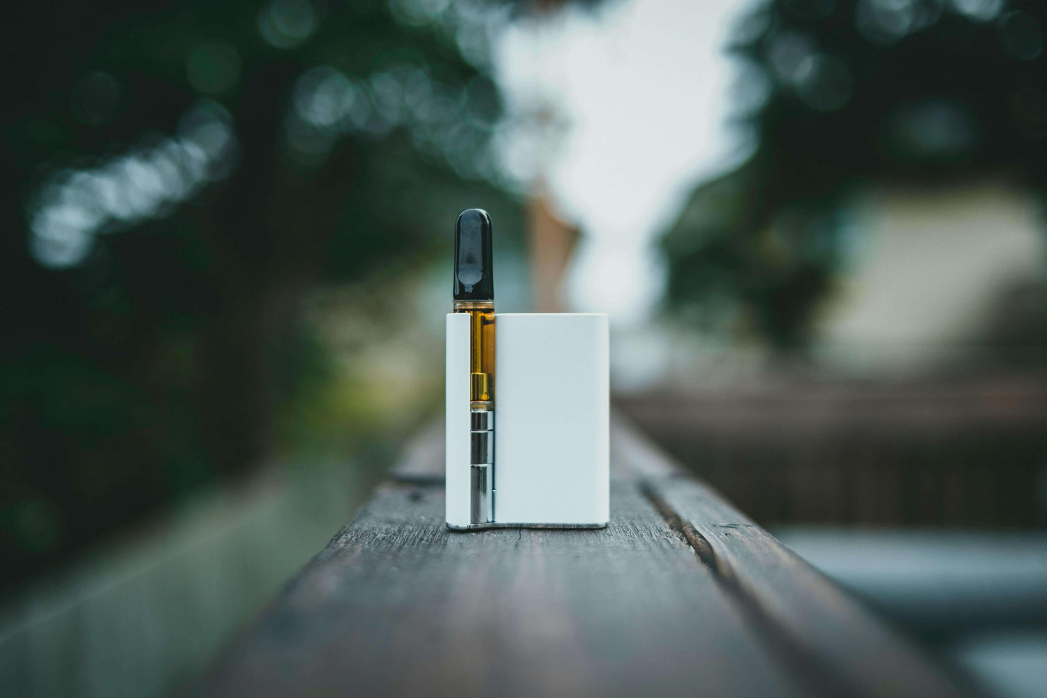 Dispositivo vape de nicotina sobre un borde de madera, resaltando su diseño elegante y funcional.