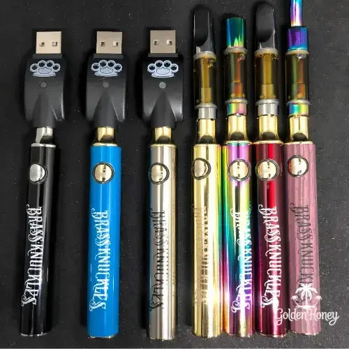 Variety of sleek THC distillation vape pens with USB chargers on a black background.