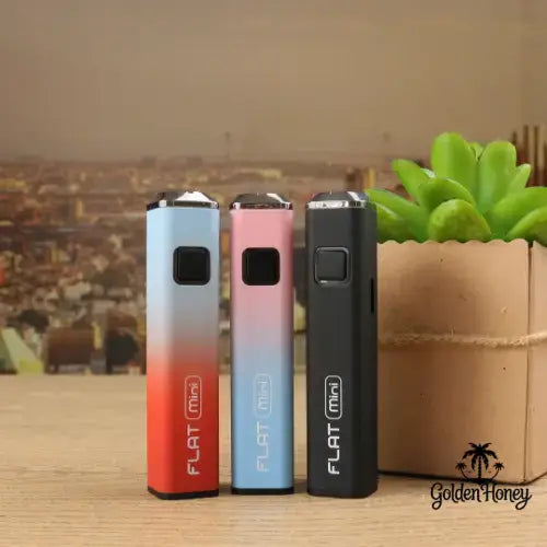 Flat Mini battery in three colors displayed with a succulent plant background.